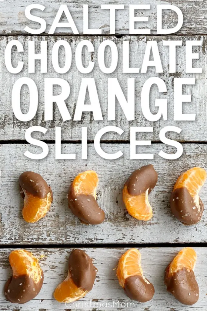 overhead view of two lines of chocolate dipped orange slices with sea salt on a grey wooden table