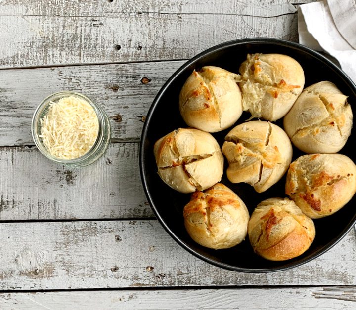 overhead view of round baking pan with garlic bread rolls