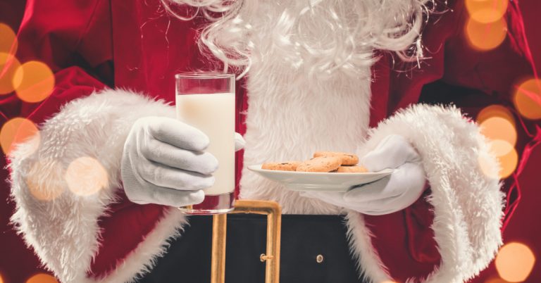 Santa Claus holding plate of cookies and glass of milk