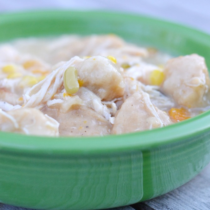 Close up of easy crock pot chicken and dumplings in a green bowl