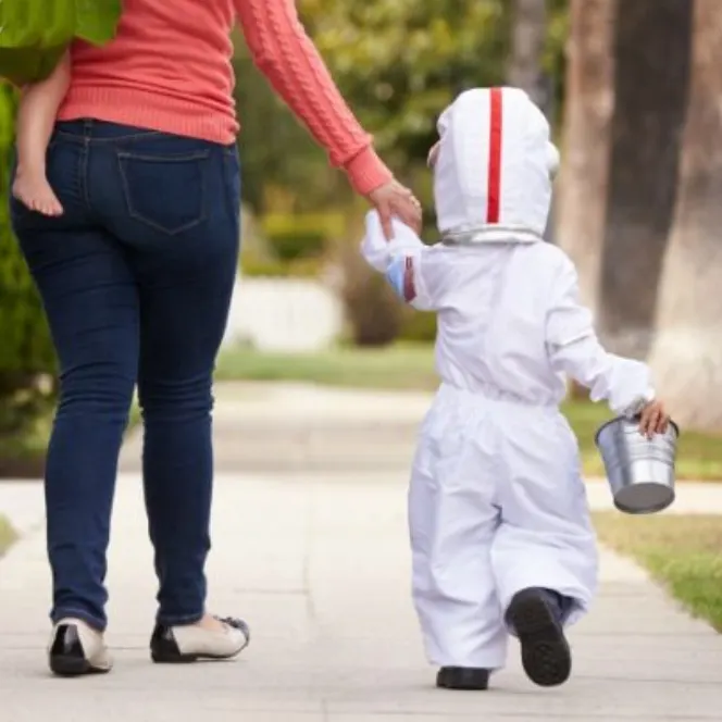 mom holding hands with a kids dressed like an astronaut for Halloween