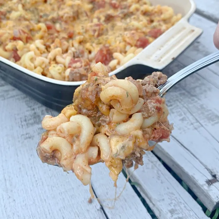 spoonful of Italian Beef Casserole with casserole dish in the background