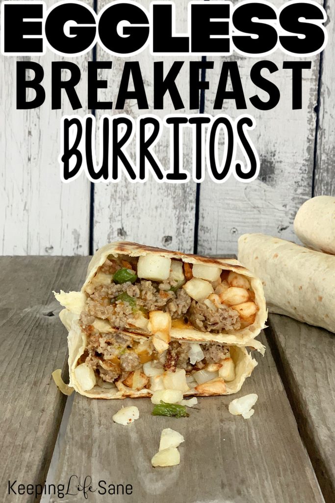 breakfast burrito without eggs cut in half to see ground sausage and hash browns on wooden table