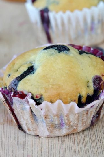 closeup view of no egg blueberry muffin on a wooden cutting board