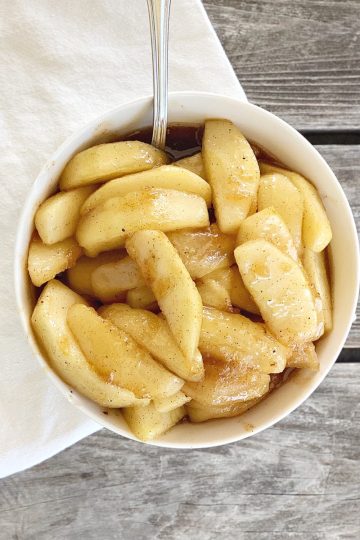 Fried Apples in White bowl with white napkin and spoon